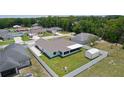 Aerial view of the backyard, featuring a screened-in patio, fenced yard and a storage shed at 15022 Se 94Th Ct, Summerfield, FL 34491