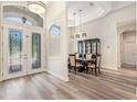 Bright foyer with decorative glass double doors, luxury vinyl flooring, and adjacent dining area at 16951 Florence View Dr, Montverde, FL 34756