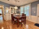 Cozy dining room with hardwood floors and a decorative chandelier illuminating the space at 175 Hibiscus Way, Leesburg, FL 34748