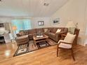 Comfortable living room featuring hardwood floors, a plush sectional, and natural light at 175 Hibiscus Way, Leesburg, FL 34748