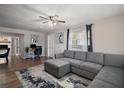 Comfortable living room area featuring a gray sofa, modern ceiling fan and a stylish desk area at 1805 Jefferson Dr, Mount Dora, FL 32757