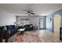 Cozy living room with a blue sofa, decorative pillows, and a glass coffee table at 2003 Cordero Ct, The Villages, FL 32159