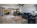 Open living area with a vibrant rug, comfortable blue sofas, and kitchen in the background at 2003 Cordero Ct, The Villages, FL 32159