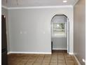 Open dining area featuring neutral walls, tile flooring, and an archway leading to another room at 23515 Poinsettia Ave, Fruitland Park, FL 34731