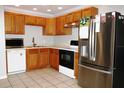 Well-lit kitchen features wooden cabinetry, stainless steel appliances, and neutral countertops at 23515 Poinsettia Ave, Fruitland Park, FL 34731