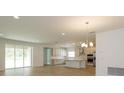Open-concept kitchen features stainless appliances, white cabinets, and an island at 2364 Juniper Berry Dr, Minneola, FL 34715