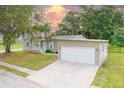 Single-story home featuring an attached two-car garage, concrete driveway, and well-maintained lawn at 25156 Buttonwood Dr # 126, Astatula, FL 34705