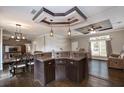 Kitchen and dining area featuring dark wood cabinetry, breakfast bar, and open layout at 25156 Buttonwood Dr # 126, Astatula, FL 34705