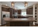 Well-equipped kitchen with dark wood cabinetry, stainless steel appliances, and a breakfast bar at 25156 Buttonwood Dr # 126, Astatula, FL 34705