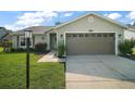 Charming single-story home with a well-maintained lawn, attached two-car garage and mature landscaping at 25406 Crestwater Dr, Leesburg, FL 34748