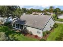 View of the back of the house featuring a screened lanai and green grass at 25406 Crestwater Dr, Leesburg, FL 34748