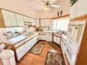 Well-lit kitchen with ample counter space, white cabinets, and modern appliances at 26612 Bella Vista Dr, Howey In The Hills, FL 34737
