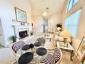 Bright living room with high ceilings, a cozy fireplace, and comfortable seating arrangement at 26612 Bella Vista Dr, Howey In The Hills, FL 34737