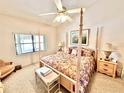 Bedroom with four poster bed, matching nightstands and sitting area at 26612 Bella Vista Dr, Howey In The Hills, FL 34737