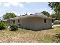 Back corner view of a well-maintained single story home with new roof and green lawn at 2701 S Dellwood Dr, Eustis, FL 32726