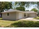Attached single-car garage of a well-maintained single story home with a concrete driveway at 2701 S Dellwood Dr, Eustis, FL 32726