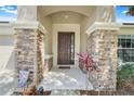 Inviting front entrance with decorative stone pillars and a charming, paneled front door at 2889 Columbus Ave, Clermont, FL 34715