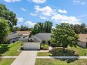 Charming single-story home with an attached two-car garage, lush landscaping, and a well-manicured lawn at 3677 Park Green Ct, Tavares, FL 32778