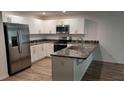 Open kitchen with granite countertops and stainless steel appliances at 435 Woodview Dr, Tavares, FL 32778