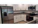 Modern kitchen featuring stainless appliances and granite counters at 435 Woodview Dr, Tavares, FL 32778