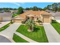 This well-maintained tan house has an inviting front yard with green grass and a convenient three-car garage at 4716 Heritage Trl, Leesburg, FL 34748