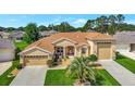 Beautifully landscaped, this tan home features an eye-catching red front door and a convenient three-car garage at 4716 Heritage Trl, Leesburg, FL 34748
