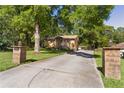 Property featuring a long private driveway flanked by brick pillars, leading to a charming brick home at 5581 Sw 197Th Ter, Dunnellon, FL 34431