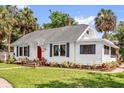 Inviting one-story home with blue shutters, a red front door, and well-maintained lawn at 647 E 3Rd Ave, Mount Dora, FL 32757