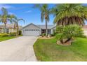 Attractive single-story home with lush landscaping, palm trees, and a well-maintained front yard at 762 Turbeville Ter, The Villages, FL 32162