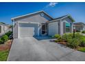 Well-maintained single-story home with a two-car garage and a concrete driveway, set under a clear blue sky at 865 Conroe St, The Villages, FL 34762