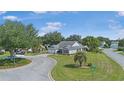 Well-maintained home with lush landscaping, blue siding, and a circular driveway at 8980 Se 176Th Limerick Ln, The Villages, FL 32162