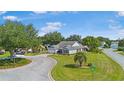 Wide angle view of a well maintained home with beautiful landscaping in a suburban neighborhood at 8980 Se 176Th Limerick Ln, The Villages, FL 32162