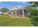 A cozy screened porch adds charm to this home, surrounded by lush landscaping and a serene backyard at 8980 Se 176Th Limerick Ln, The Villages, FL 32162