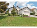 Single-story home featuring lush lawn, manicured landscaping, and attached two-car garage at 9307 San Jose Blvd, Howey In The Hills, FL 34737