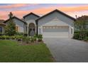 Charming single-story home featuring a manicured lawn, brick driveway, and attached two-car garage at 9307 San Jose Blvd, Howey In The Hills, FL 34737