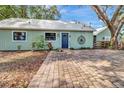 A charming exterior view of a home with a blue front door and brick paver parking at 10330 Dwights Rd, Clermont, FL 34714