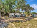 Aerial view of a lovely green home with mature trees and a charming barn-style shed at 10330 Dwights Rd, Clermont, FL 34714
