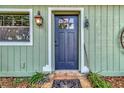 Inviting front door of a home, featuring a black door with glass panes and rustic lantern at 10330 Dwights Rd, Clermont, FL 34714