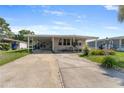 Inviting single-story home with a covered carport and well-manicured landscaping, plus a concrete driveway at 1113 Elkhart Cir, Tavares, FL 32778