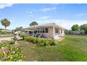Well-maintained single-story home featuring an inviting covered patio, mature landscaping, and a bright exterior at 1113 Elkhart Cir, Tavares, FL 32778