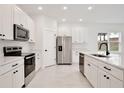 Modern kitchen featuring white cabinets, stainless steel appliances, and quartz countertops at 1191 Stratton Ave, Groveland, FL 34736