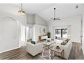 Bright living room with high ceilings, modern decor, and sliding glass doors to the outside at 12838 Owasso Ln, Clermont, FL 34711