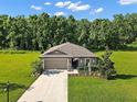 Expansive lawn and manicured landscaping surround this beautiful home in a serene and lush setting at 12952 Del Lago Dr, Astatula, FL 34705