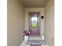 Inviting front entryway featuring a decorative glass door, welcome mat, and charming floral arrangements at 12952 Del Lago Dr, Astatula, FL 34705