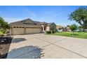 Spacious driveway leading to a charming home with a three-car garage and well-maintained landscaping at 13100 Lakewind Dr, Clermont, FL 34711