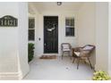 Inviting front porch with two chairs, decorative door wreath, and a welcome mat at 14421 Vashons Way, Winter Garden, FL 34787