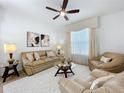 Bright living room with plush seating, decorative pillows, glass-topped coffee table, and elegant window treatments at 1454 Westbury Dr, Clermont, FL 34711