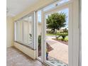 Enclosed lanai with tiled floor, offering peaceful views of the landscaped front yard at 1514 Vandam St, The Villages, FL 32162