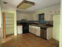 Functional kitchen features classic cabinetry, tile floors, and stainless steel appliances at 15587 Se 150Th Ave, Weirsdale, FL 32195