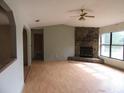 Open-concept living room with hardwood floors and stone fireplace, bathed in natural light at 15587 Se 150Th Ave, Weirsdale, FL 32195